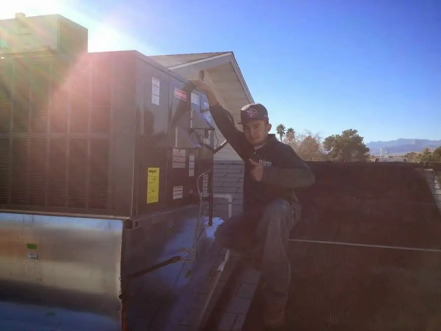 HVAC technician performing Air Duct Cleaning on a rooftop unit in Lincoln